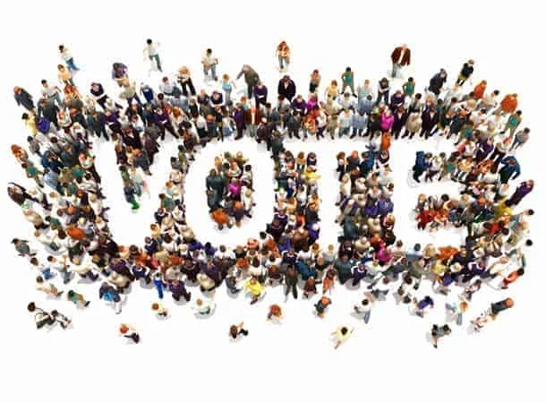 people standing together making the word vote