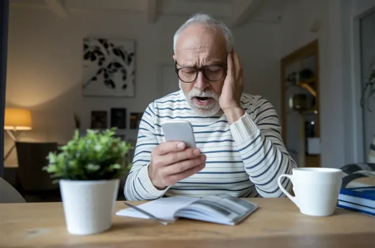 Older gentleman looking at his phone after being scanned