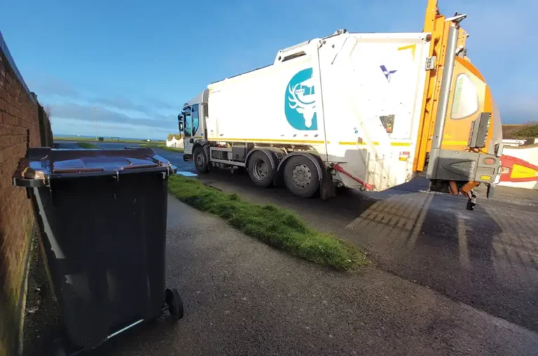 NFDC refuse vehicle and a wheely bin in front on the pavement