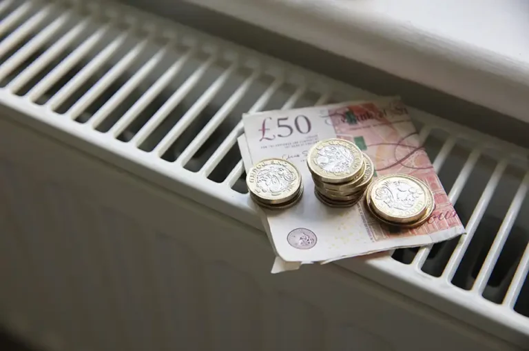 Money on a radiator, a £50 pounds and some £1 and £2 coins